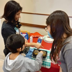 students examining items at a physics fair